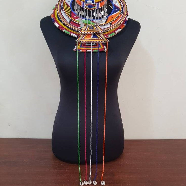 Colorful beaded necklace on a mannequin bust against a plain background