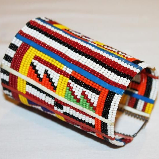 Colorful beaded cylindrical container on a light background