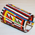 Colorful beaded cylindrical container on a light background