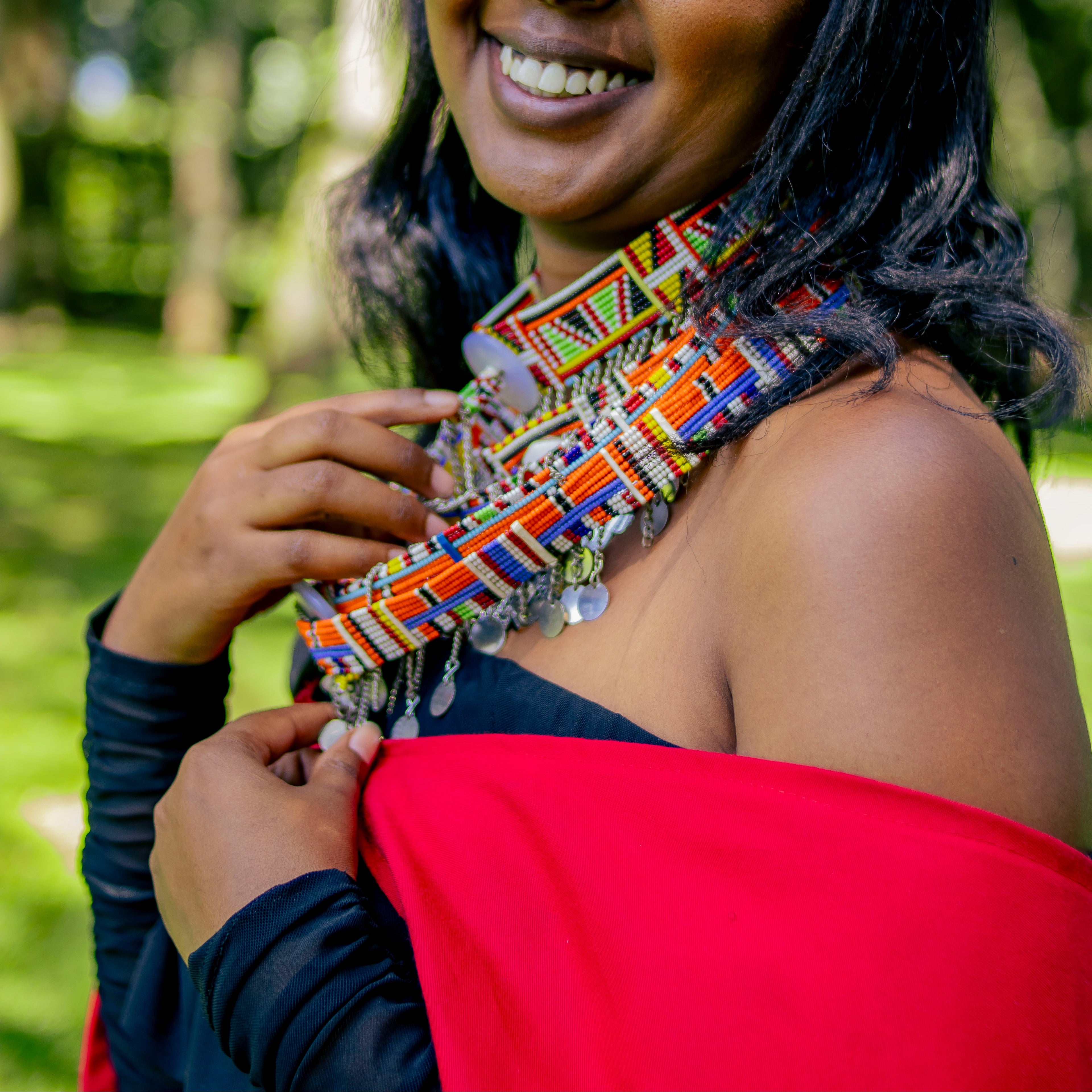 Woman wearing a colorful necklace and red garment outdoors