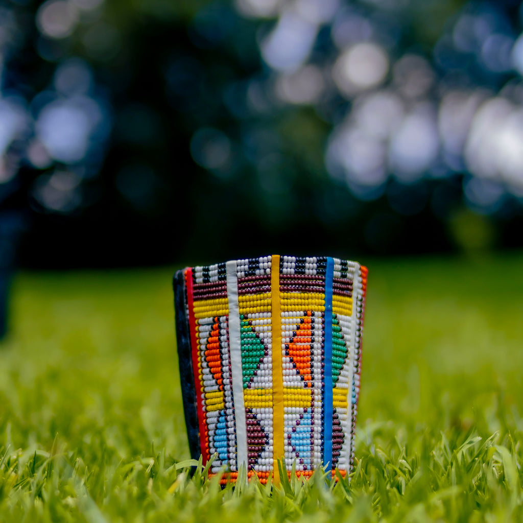 Colorful beaded pouch on grass with blurred background