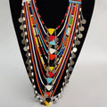 Colorful beaded necklace on a black mannequin against a white background
