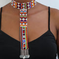 Colorful beaded necklace with dangling elements on a person wearing a black top.