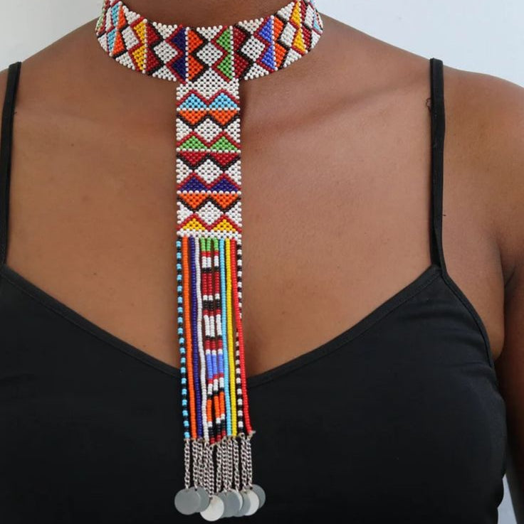 Colorful beaded necklace with dangling elements on a person wearing a black top.